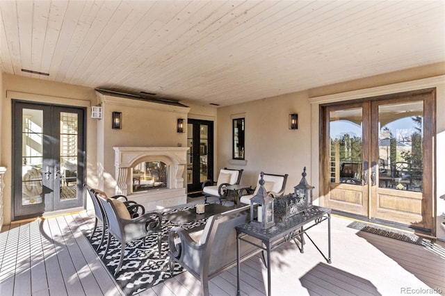 deck with french doors and a tiled fireplace