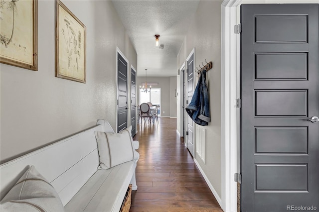 hallway featuring dark wood-type flooring and a textured ceiling