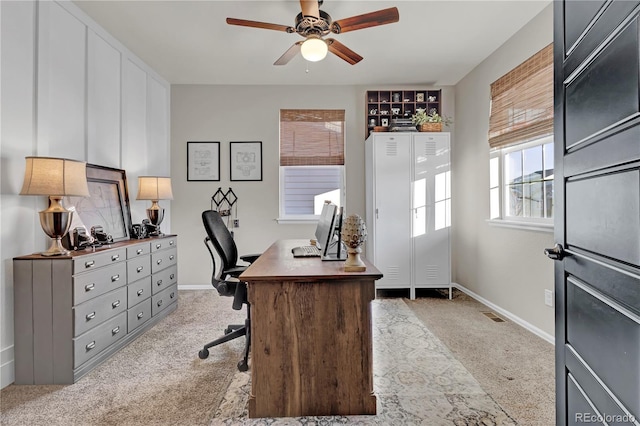 carpeted home office featuring ceiling fan