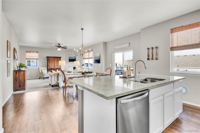 kitchen with white cabinetry, sink, stainless steel dishwasher, and a kitchen island with sink