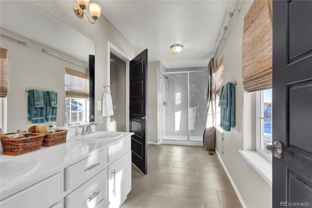 bathroom featuring vanity, a wealth of natural light, and a shower with door