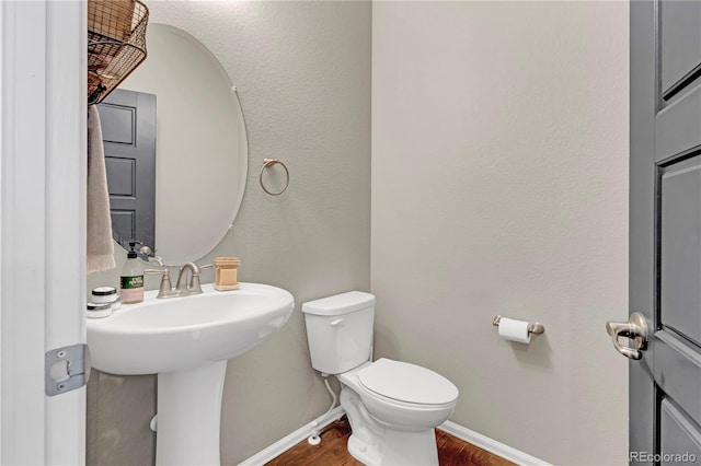 bathroom featuring hardwood / wood-style flooring, sink, and toilet