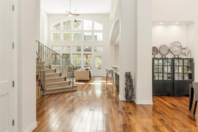 155 S Poplar St, Denver, CO 80230 - foyer featuring ceiling fan, wood-type flooring, arched walkways, a towering ceiling, and stairway