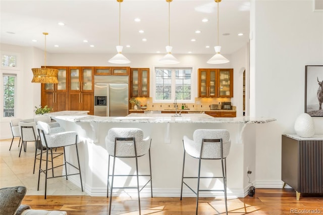 155 S Poplar St, Denver, CO 80230 - kitchen featuring built in refrigerator, brown cabinets, tasteful backsplash, a sink, and a kitchen bar