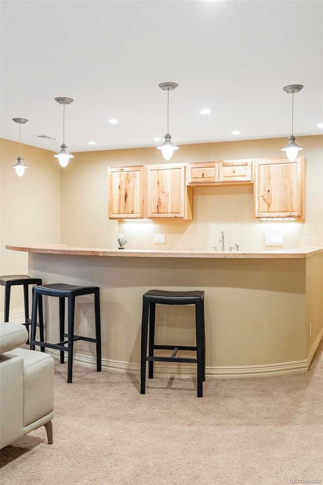 155 S Poplar St, Denver, CO 80230 - kitchen featuring light brown cabinetry, light colored carpet, a kitchen bar, baseboards, and recessed lighting
