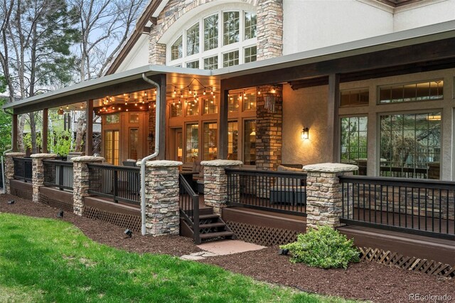 155 S Poplar St, Denver, CO 80230 - rear view of property with covered porch, stucco siding, and stone siding