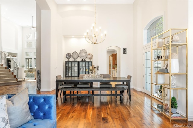 155 S Poplar St, Denver, CO 80230 - dining space featuring arched walkways, a high ceiling, hardwood / wood-style flooring, a chandelier, and stairway