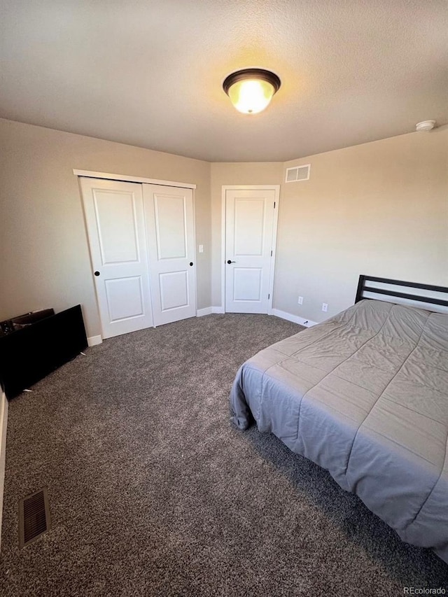 bedroom featuring visible vents, baseboards, carpet, and a closet