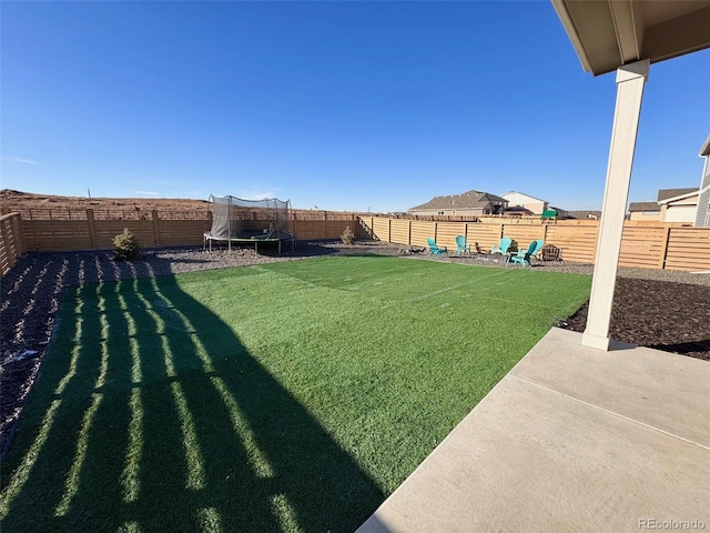 view of yard with a fenced backyard, a patio, and a trampoline