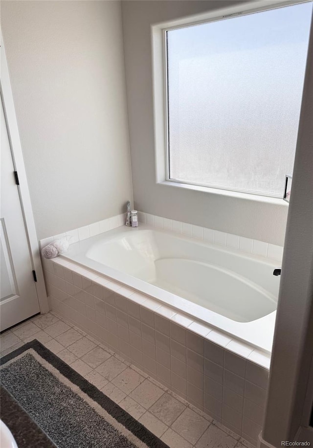 bathroom with tile patterned flooring and a garden tub