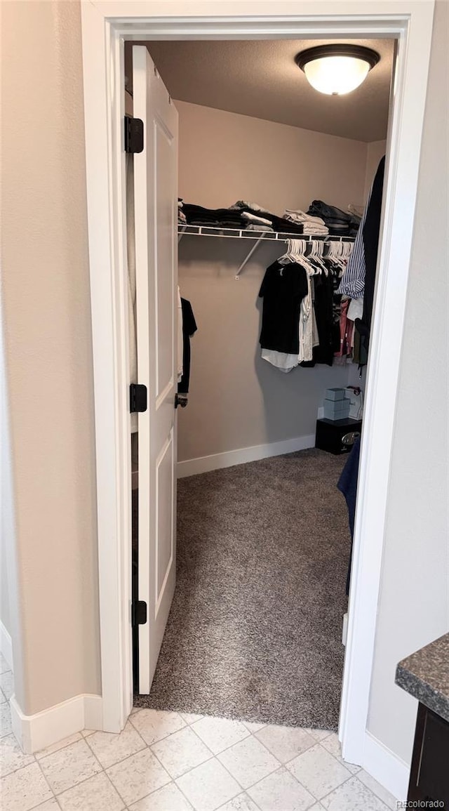 walk in closet featuring light colored carpet