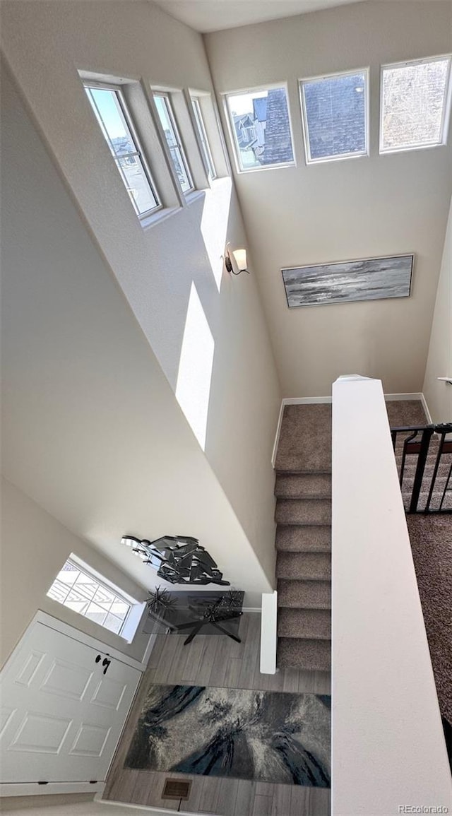 staircase with a high ceiling and baseboards