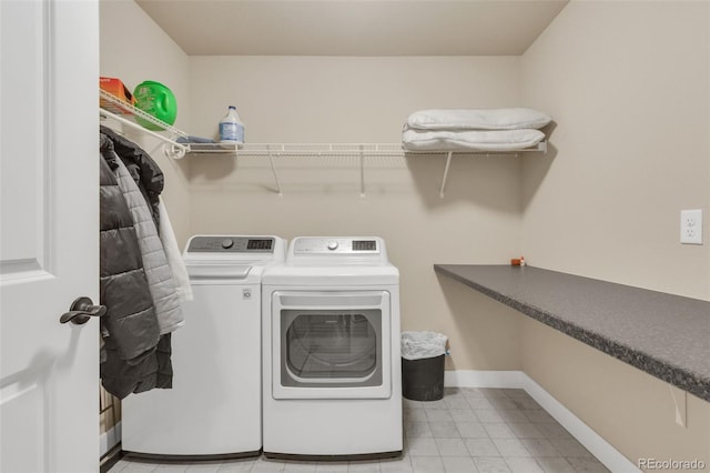 washroom featuring baseboards, laundry area, and washer and clothes dryer