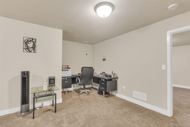 carpeted office featuring visible vents and baseboards