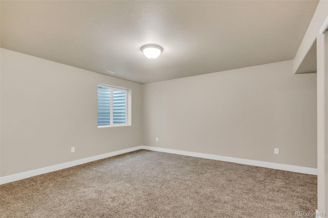 spare room featuring baseboards and carpet flooring