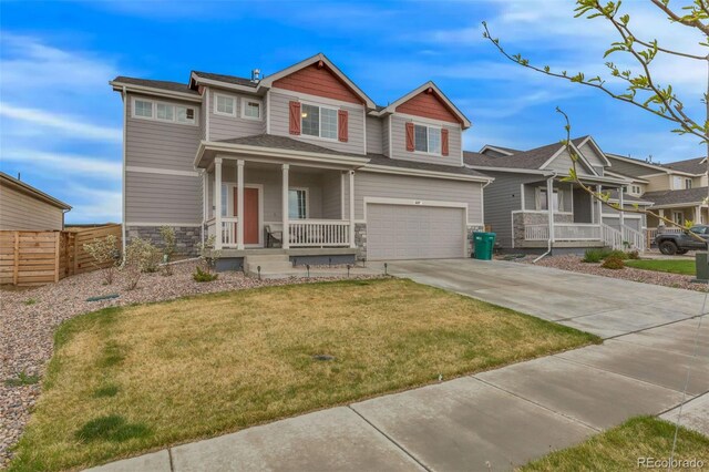 craftsman-style house featuring a porch, a front lawn, driveway, and stone siding