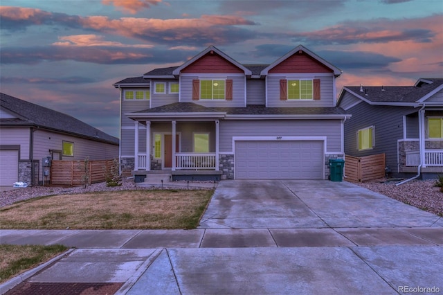 craftsman house featuring roof with shingles, an attached garage, stone siding, covered porch, and driveway