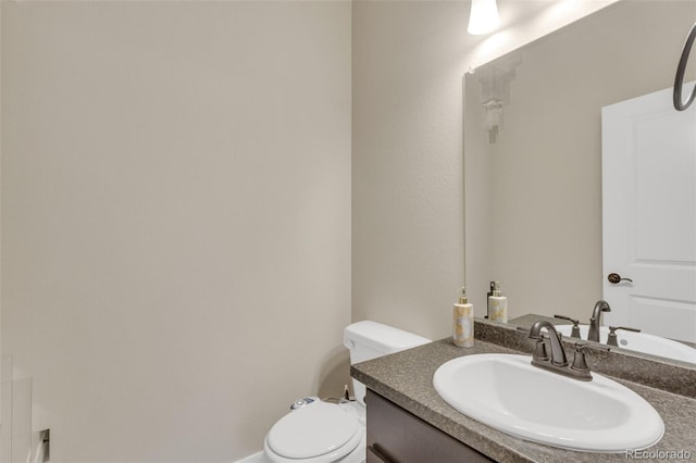 half bathroom featuring vanity and toilet