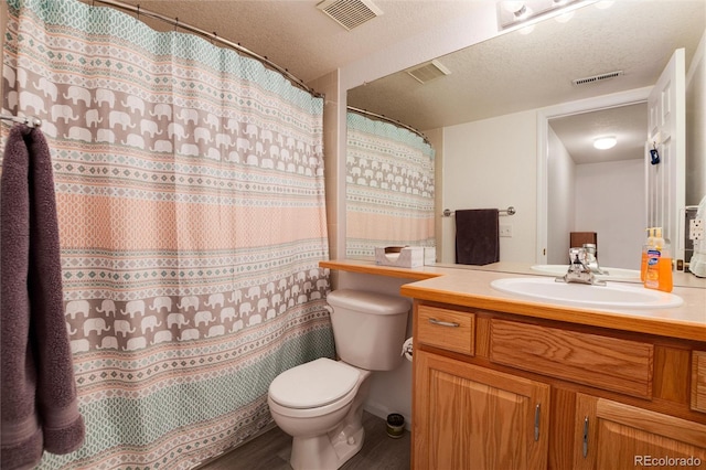 bathroom featuring toilet, vanity, a shower with curtain, hardwood / wood-style flooring, and a textured ceiling