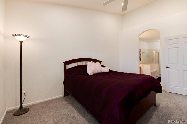 carpeted bedroom with ensuite bath and ceiling fan