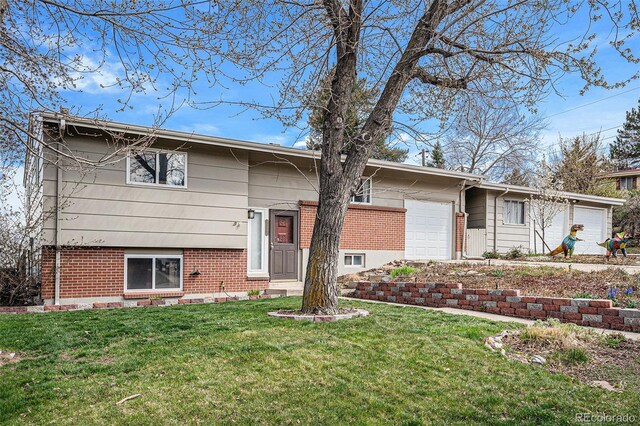 split foyer home featuring brick siding, an attached garage, and a front lawn