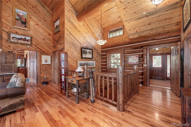 foyer with wooden walls, high vaulted ceiling, wooden ceiling, and light wood-type flooring