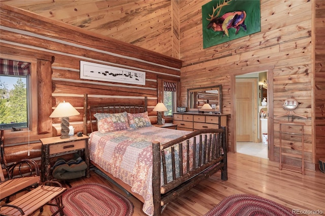 bedroom featuring light hardwood / wood-style floors, wood walls, multiple windows, and wooden ceiling