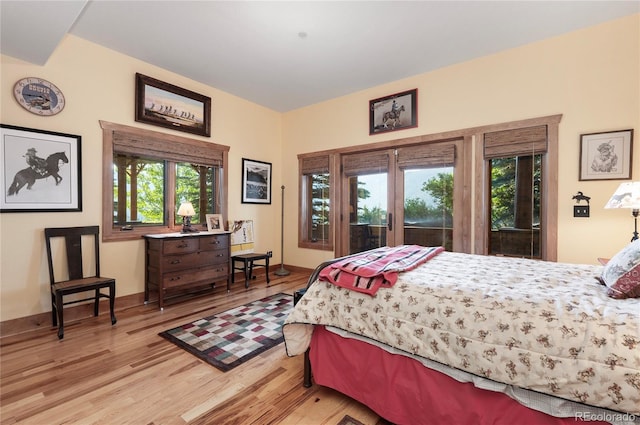 bedroom featuring access to exterior, french doors, and light hardwood / wood-style flooring