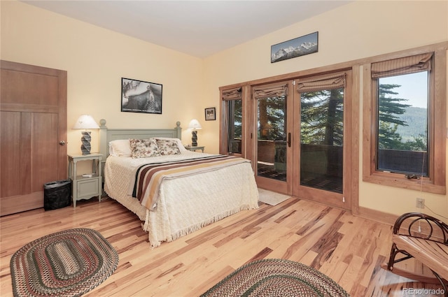 bedroom with access to exterior and light hardwood / wood-style flooring