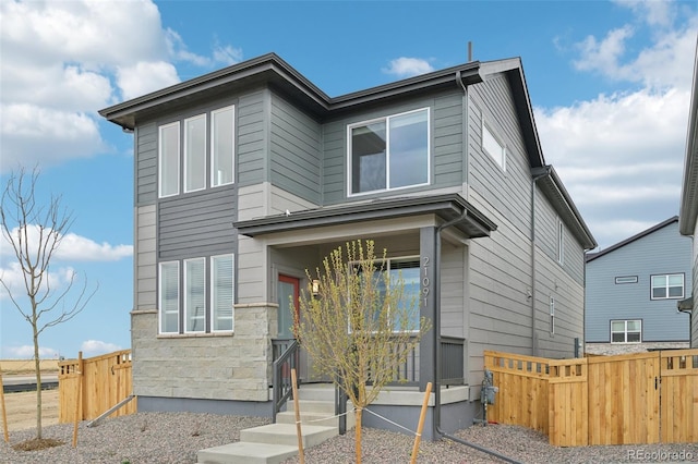 view of front of home with fence and stone siding