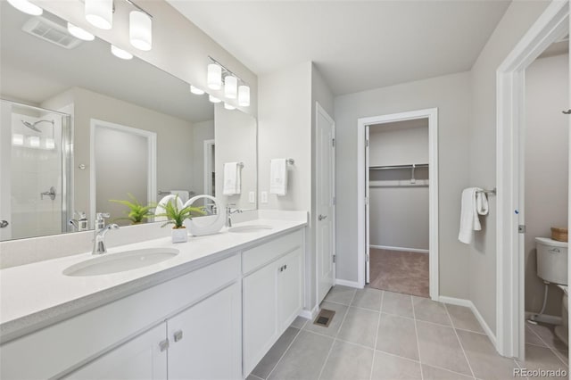 bathroom featuring a shower stall, tile patterned floors, a sink, and visible vents