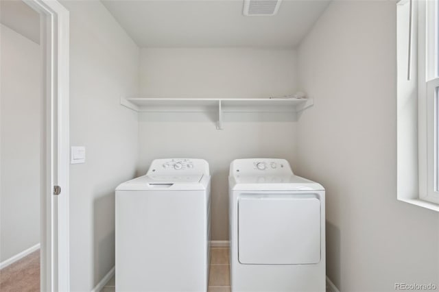 laundry area featuring visible vents, baseboards, washing machine and dryer, and laundry area