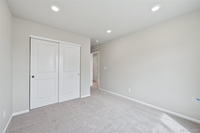unfurnished bedroom featuring a closet, recessed lighting, baseboards, and carpet floors