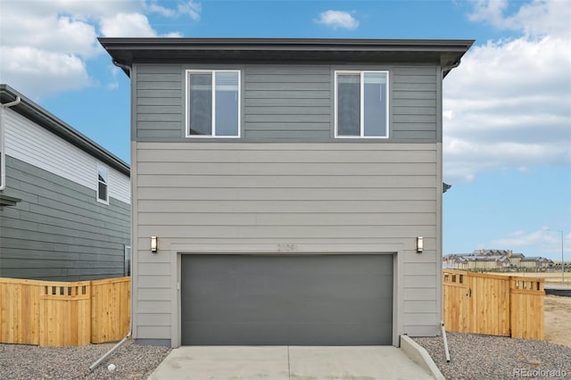 view of front of home with driveway, fence, and an attached garage