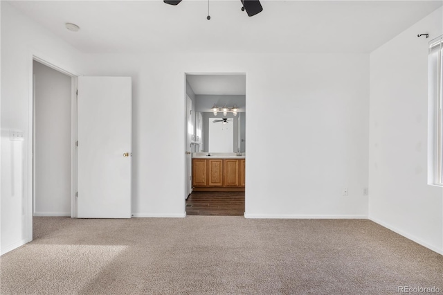 unfurnished bedroom featuring ensuite bath, ceiling fan, and carpet floors