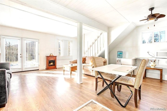 dining area featuring a ceiling fan, light wood-style floors, and stairs