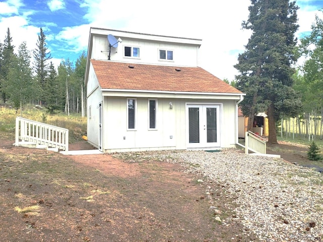 rear view of house with french doors and roof with shingles