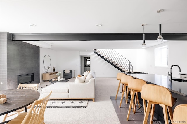 tiled living room featuring a large fireplace and sink