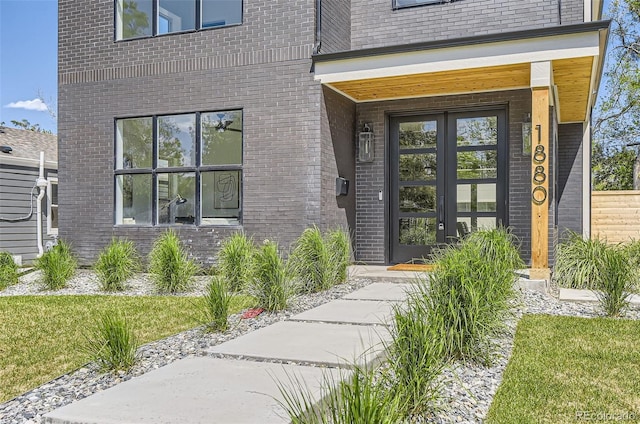 doorway to property featuring brick siding and french doors