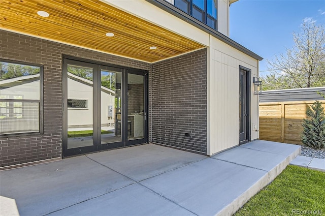 doorway to property featuring brick siding and a patio
