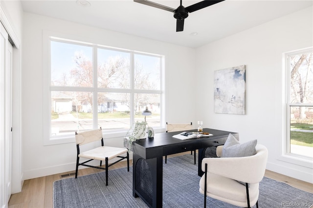 home office with ceiling fan, light wood-type flooring, and baseboards