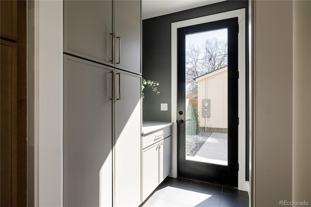 doorway to outside featuring dark tile patterned floors and plenty of natural light