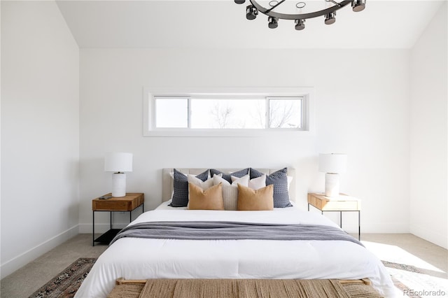 carpeted bedroom with baseboards and a chandelier
