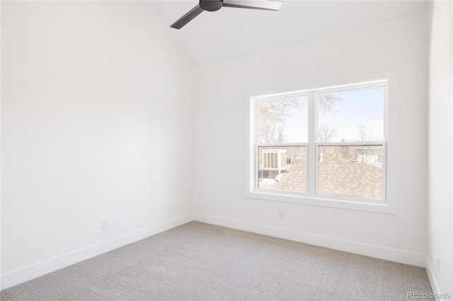 spare room featuring carpet floors, ceiling fan, baseboards, and vaulted ceiling