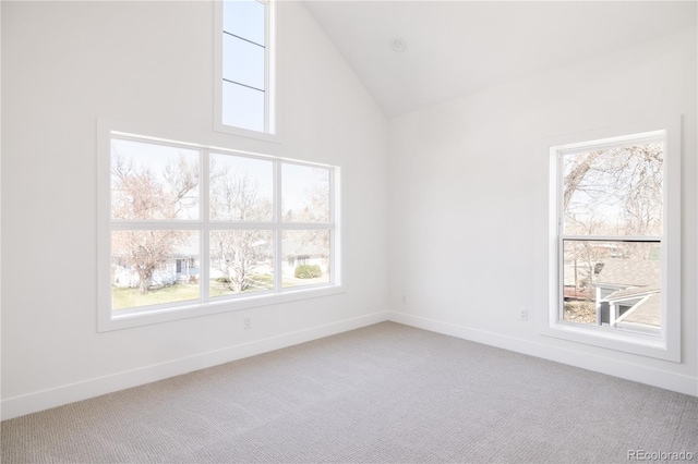 empty room featuring carpet, baseboards, and high vaulted ceiling
