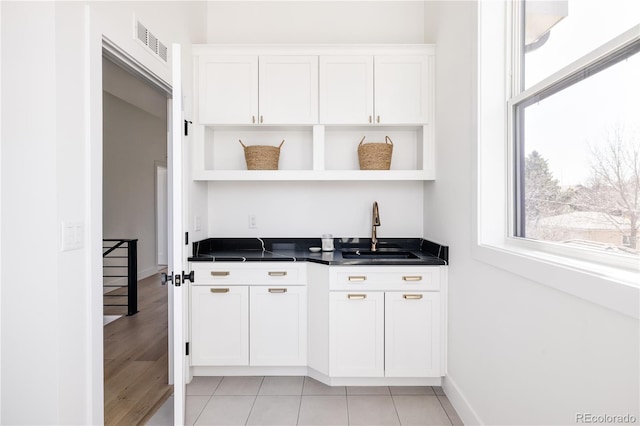 bar area with a sink, healthy amount of natural light, and baseboards