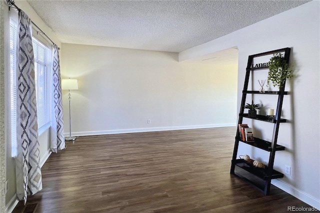 spare room with dark wood-type flooring and a textured ceiling