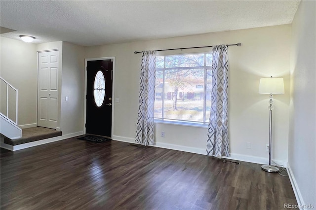 foyer with dark hardwood / wood-style floors and a textured ceiling