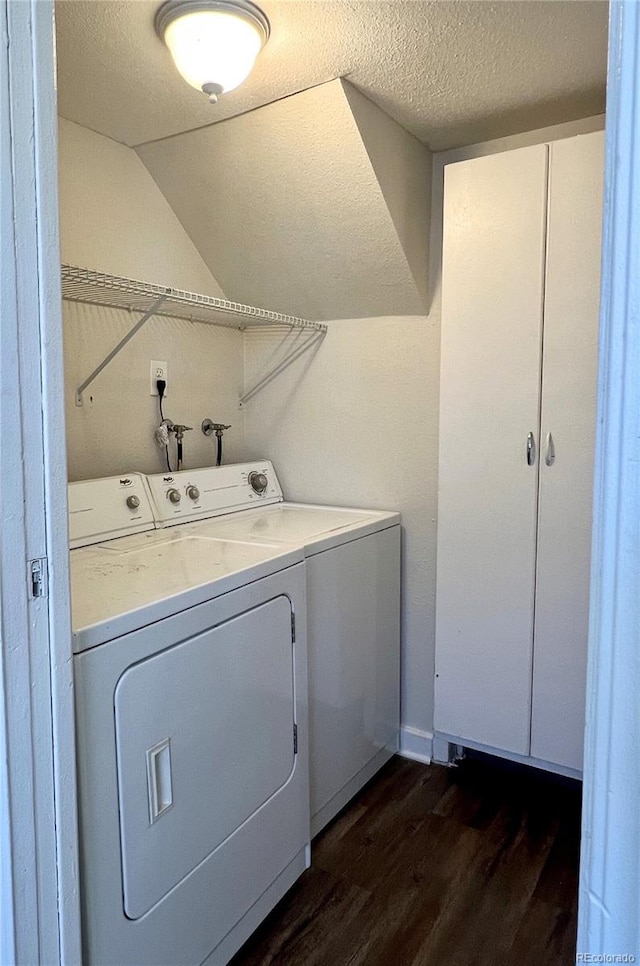 washroom featuring dark wood-type flooring, a textured ceiling, and washer and clothes dryer