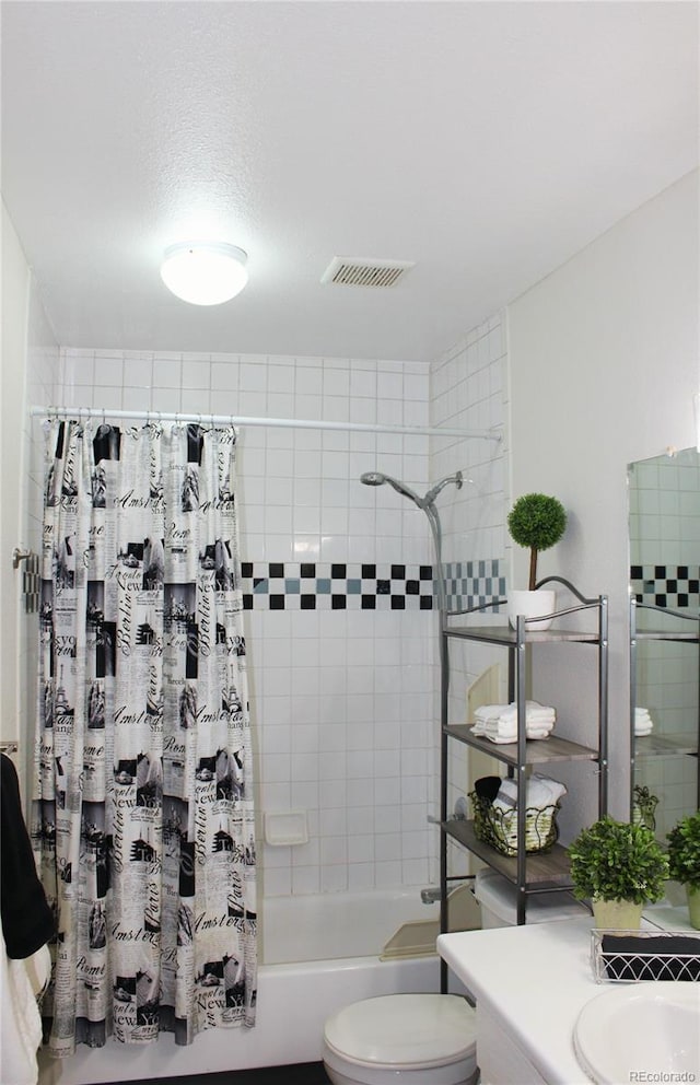 full bathroom with vanity, toilet, a textured ceiling, and shower / bath combo